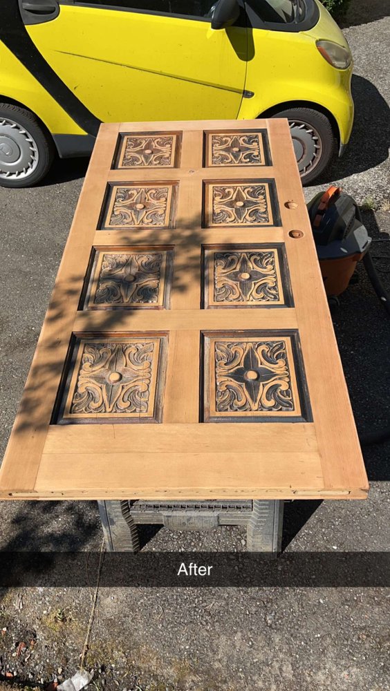 Ornate carved entry door after refinishing — beautiful natural wood