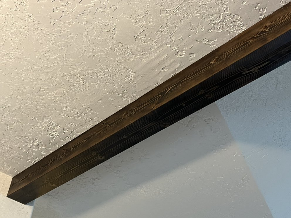 Custom dark walnut faux beam installed on ceiling